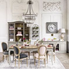 an elegant dining room with chandelier, table and chairs