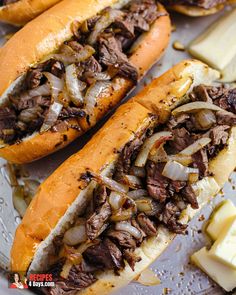 two sandwiches with meat, onions and cheese on a plate