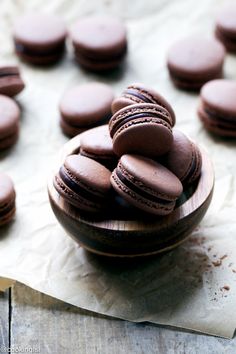 a wooden bowl filled with chocolate macaroons