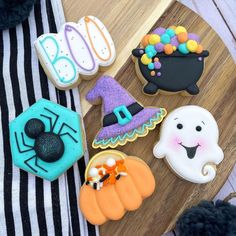 decorated halloween cookies on a wooden board with black and white stripes