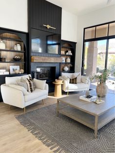 a living room filled with furniture and a fire place in front of a large window