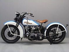 a white and blue motorcycle parked on top of a gray floor