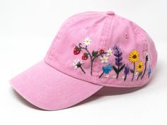 This hand embroidered flower baseball cap is a one-of-a-kind accessory that combines style and comfort. The cap is crafted from high-quality material, ensuring durability and comfort. The intricate floral design is hand-embroidered, giving each cap a unique touch and making it a standout piece. Whether you're running errands or enjoying a day outdoors, this cap will keep the sun out of your eyes in style. Flower is 100% hand embroidered on a 100% cotton wash baseball cap. Hat is one size fits al Spring Cotton Snapback Cap, Whimsical Adjustable Baseball Cap, Adjustable Whimsical Baseball Cap, Casual Pink Embroidered Dad Hat, Spring Adjustable Snapback Hat With Curved Visor, Spring Snapback Hat With Curved Brim, Pink Cotton Dad Hat For Spring, Casual Pink Embroidered Baseball Cap, Pink Dad Hat Snapback For Spring