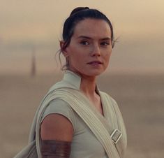 a woman in a star wars outfit with her arm wrapped around her shoulder and looking at the camera