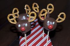 chocolate covered pretzels in the shape of reindeers on a red and white striped napkin