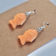 If you or someone you know loves taiyaki, then this pair of earrings will be perfect for you and/or be the perfect gift! They are made of polyresin and have an eardrop height of 3.7 centimeters and an eardrop width of 1.4 centimers. They are also a one size fits all!  Thanks for stopping by and feel free to message me with questions if you have any! ツ Japanese Earrings, Crazy Earrings, Earrings Japanese, Baked Cake, Anime Earrings, Food Cute, Japanese Fish, Fish Earrings, Earrings Aesthetic