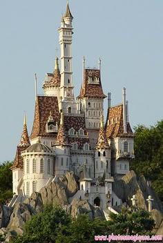 the castle is built on top of some rocks and has many spires that look like it's going to fall down