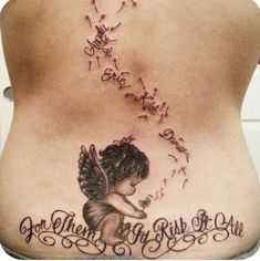 the back of a woman's stomach with an angel tattoo on it and words written in cursive writing