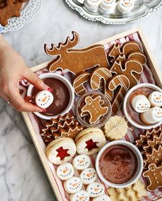 a tray filled with lots of different types of cookies and desserts on top of a table