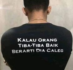 the back of a woman's black shirt with white writing on it that says kalauu orange tibatba bak bera dia caleg