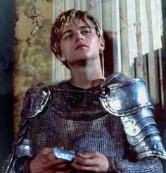 a young man dressed in armor holding a remote control