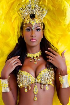 a woman in a yellow costume posing for the camera with feathers on her head and chest