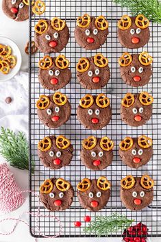 christmas cookies decorated with pretzels and reindeer noses on a cooling rack next to other holiday treats