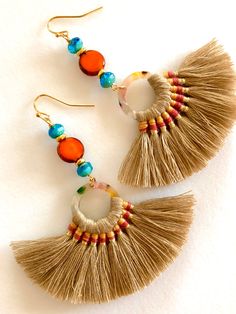 "Summery woven fan tassel earrings in sandy beige with burnt orange and aqua Czech glass accents. Tan fan tassels are woven with orange accents on acetate rings. Measure 70 x 45mm. Burnt orange Picasso coin beads and Mykonos aqua blue Czech glass beads add fun colors. Earrings hang from gold plated French hooks. Total length is 3 1/2\". Lightweight and summery!" Brown Dangle Tassel Earrings For Summer, Brown Bohemian Tassel Earrings For Summer, Bohemian Brown Tassel Earrings For Summer, Adjustable Brown Bohemian Tassel Earrings, Multicolor Beaded Tassel Earrings For Beach, Beach Jewelry With Brown Tassels, Brown Tassel Earrings For Summer, Brown Bohemian Tassel Earrings, Bohemian Brown Tassel Earrings