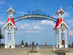 the entrance to an amusement park with two red and white buildings on it's sides