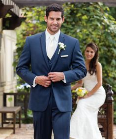 a man in a suit and tie standing next to a woman