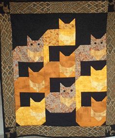 a quilted wall hanging with cats on it's sides and in the middle