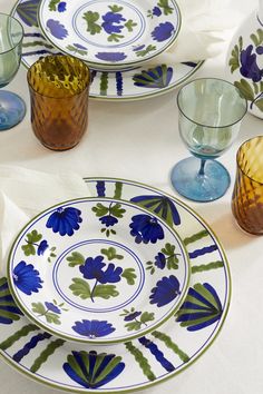 a table topped with plates and glasses filled with different types of dishes on top of each other