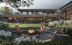 a fire pit surrounded by chairs in front of a house