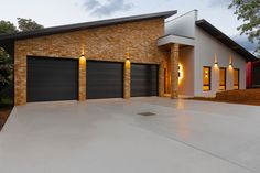 a brick house with two garages and lights on