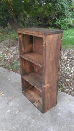 a wooden book shelf sitting on top of a sidewalk