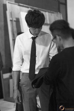 black and white photograph of two men in business attire looking at something on the wall