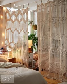 a bedroom with macrame curtains hanging from the ceiling and lights on the wall