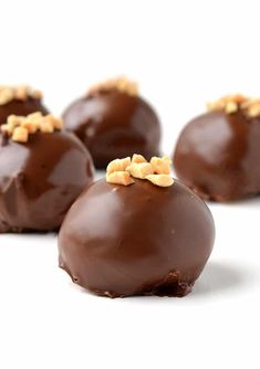 four chocolate covered candies with nuts on top