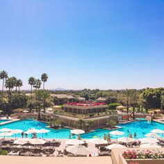 an aerial view of a resort pool with umbrellas