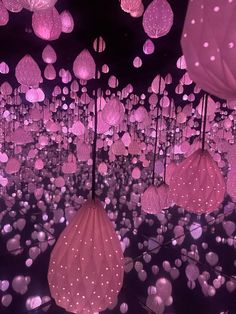 many pink umbrellas floating in the air with lights on them and dots all over