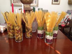 there are many vases with different types of food in them on the table next to each other