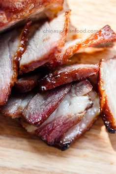 sliced bacon sitting on top of a wooden cutting board