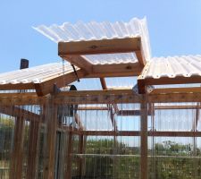 a wooden structure with glass doors and roof