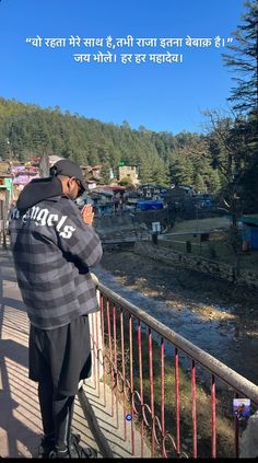 a man standing on top of a bridge next to a river