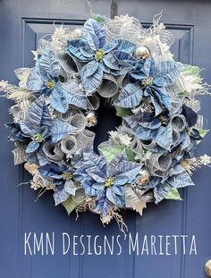 a blue door with a wreath on it that says kimn design's marietta