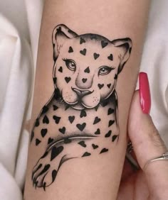 a black and white tattoo of a cheetah with hearts on it's leg