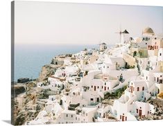 an aerial view of white buildings on the cliff by the ocean