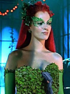 a woman with long red hair and green makeup in a scene from the movie maleficent