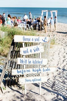 a wooden sign sitting on top of a sandy beach