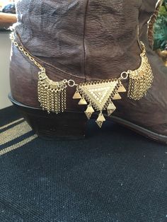 This handmade Gold Metal Boot Jewelry features an Aztec triangle pendant with opal crystals & small triangle charms. It is flanked by 2 u-shaped chain charms & has gold chain with a lobster clasp.  It measures 13" +3" extension. This item is sold as a single. This piece is designed with the bold woman in mind. Wear them to concerts, festivals, parties, weddings, or anytime when you need that extra glitz. Made in the USA. Return & Exchange Policy I will gladly accept returns or exchanges on items Gold Boots, Boot Bracelet, Silver Boots, Boot Jewelry, Triangle Pendant, Bracelet Boho, Jewelry Bracelet, Handmade Gold, Anklet Jewelry