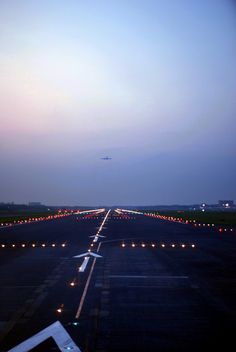 an airplane that is sitting on the tarmac at night with lights all around it