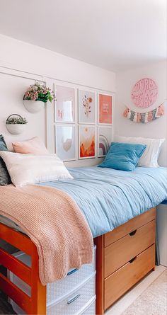 a bedroom with a bed, dresser and pictures on the wall