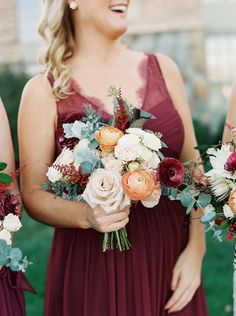 the bridesmaids are holding their bouquets and smiling at each other while standing outside