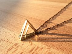 "This adorable geometric necklace is handmade with 4 equilateral cut raw brass triangles of varying size, width, and metal finish (brass, gold, & silver). The equilateral triangle is an ancient symbol used to represent many things throughout time, the number 3; a trilogy, the symbol for deity or the holy trinity, the free masons, the illuminati, the family: the union of two that creates the third. Traditionally, an upside down equilateral triangle was the pagan symbol for female, while a right s Free Masons, Sacred Geometry Jewelry, Geometry Jewelry, Equilateral Triangle, Pagan Symbols, Tri Delta, Gold Triangle, Engraved Pendant, Triangle Necklace