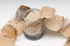 a jar filled with lots of different types of cookies on top of a white table