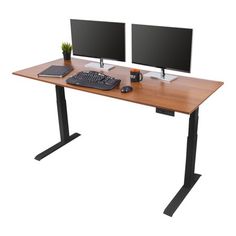 two computer monitors sitting on top of a wooden desk next to a keyboard and mouse