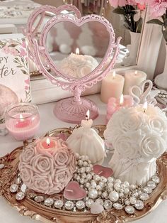 a table topped with lots of pink and white decorations