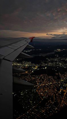 an airplane wing flying over a city at night