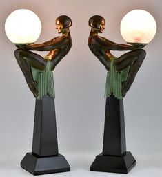 pair of art deco bronze and glass lamps with woman sitting on pedestals facing each other