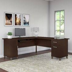 a computer desk sitting on top of a rug in front of a wall mounted tv